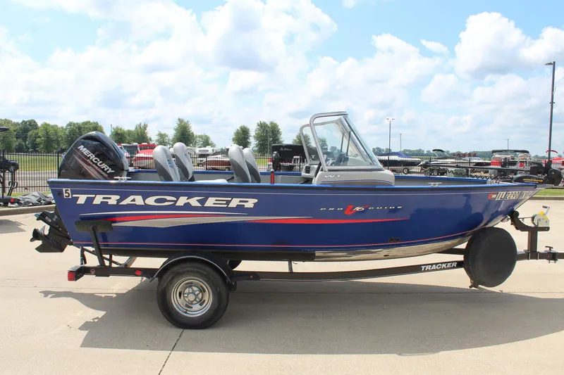 Slide: The Image of 2016 Tracker Pro Guide V-16 WT boat on trailer, blue with Mercury outboard motor. - 4