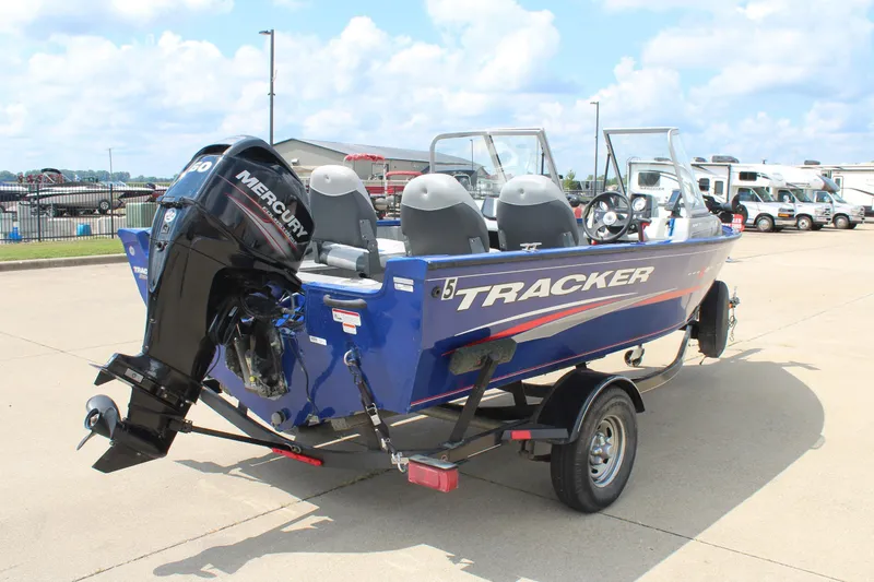 Slide: The Image of 2016 Tracker Pro Guide V-16 WT boat with Mercury engine on trailer, parked outdoors. - 5
