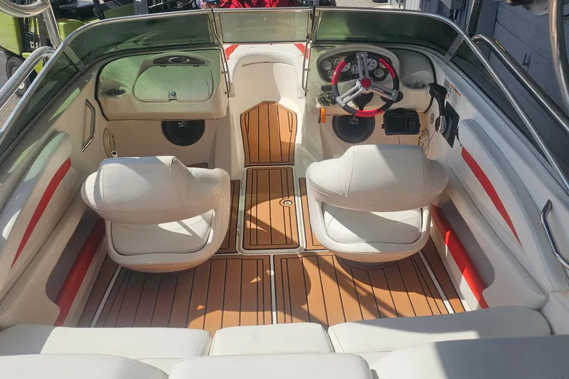 Slide: The Image of 2008 Glastron GT 205 boat interior with white seats and wood-style flooring. - 10