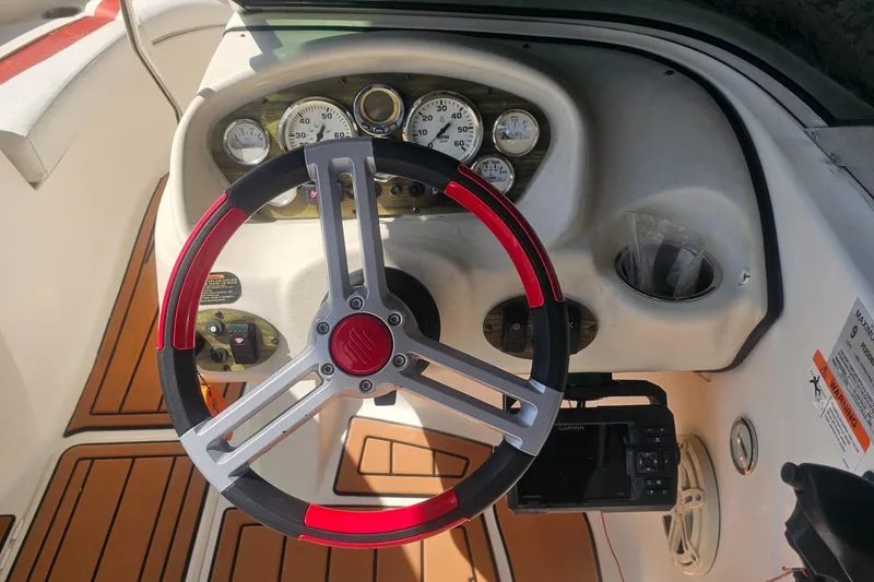 Slide: The Image of 2008 Glastron GT 205 boat dashboard with red and black steering wheel. - 11