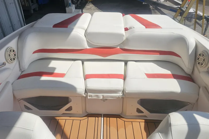 Slide: The Image of 2008 Glastron GT 205 boat interior with white and red seating, wooden flooring. - 14