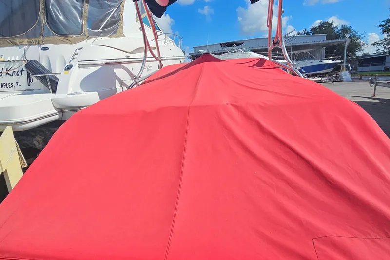 Slide: The Image of 2008 Glastron GT 205 boat covered with a red tarp in a marina setting. - 7