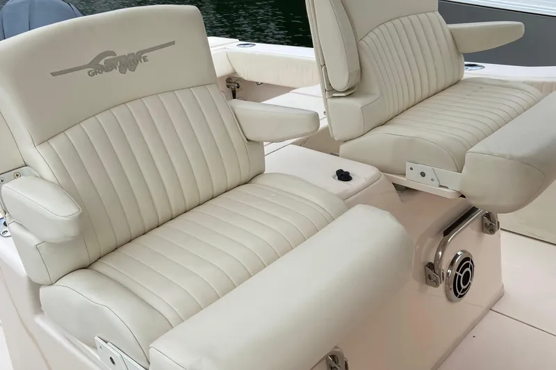 Slide: The Image of 2013 Grady-White Canyon 306 boat seats with armrests, featuring beige upholstery. - 16