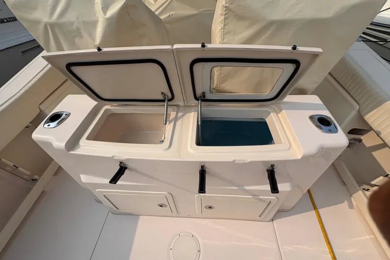 Slide: The Image of 2013 Grady-White Canyon 306 boat with open storage compartments and rod holders. - 18