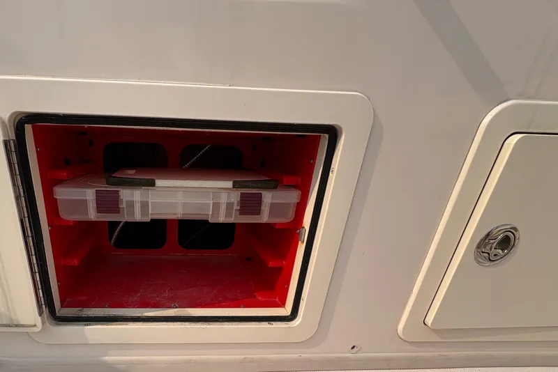 Slide: The Image of Storage compartment on a 2013 Grady-White Canyon 306 boat, featuring a red interior. - 21