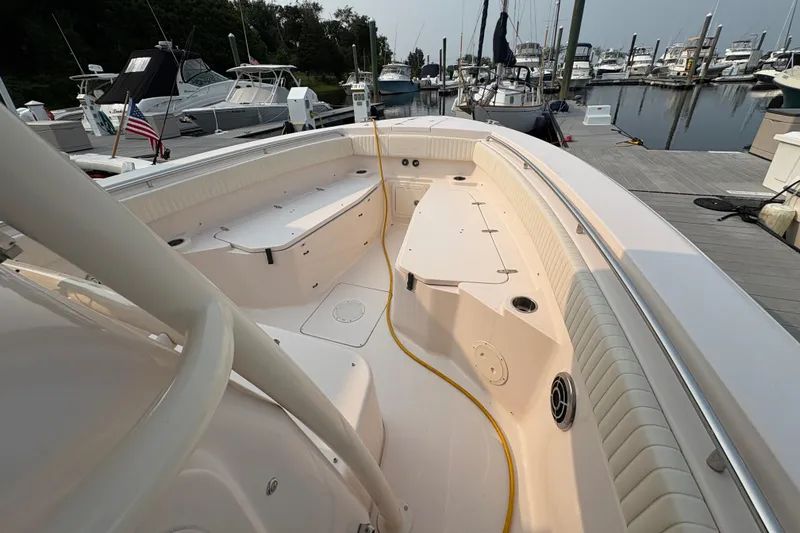 Slide: The Image of 2013 Grady-White Canyon 306 boat docked at marina, showcasing spacious deck layout. - 23