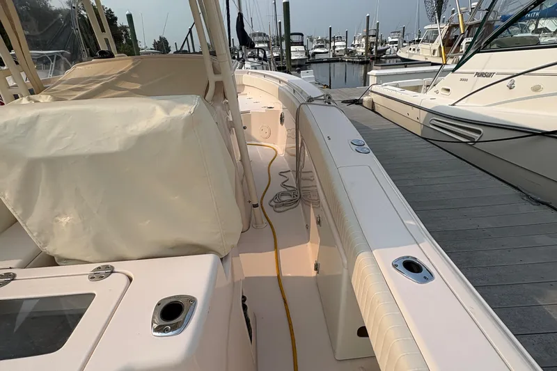 Slide: The Image of 2013 Grady-White Canyon 306 boat docked at marina, showcasing spacious deck layout. - 25