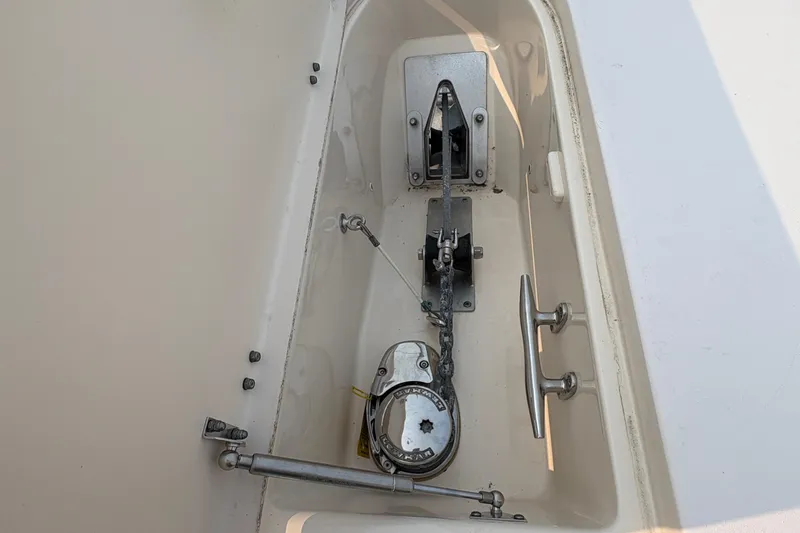 Slide: The Image of Anchor compartment of 2013 Grady-White Canyon 306 boat, featuring winch and cleat. - 27