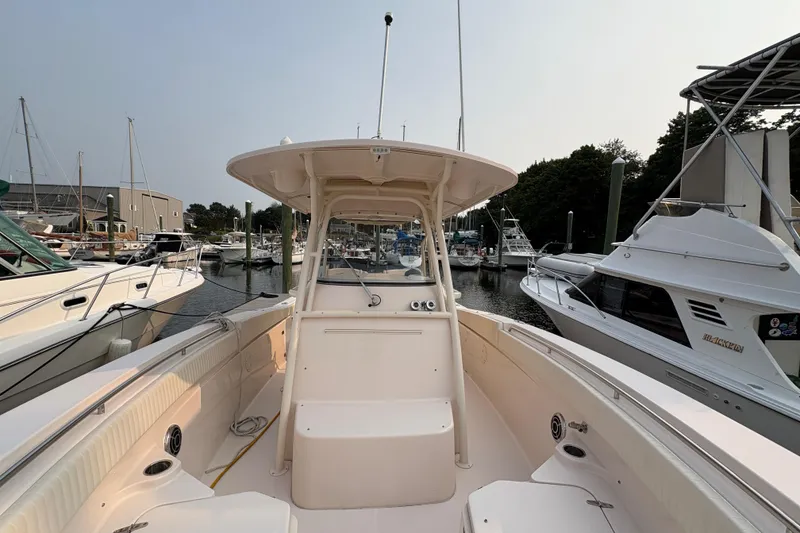 Slide: The Image of 2013 Grady-White Canyon 306 boat docked at marina, surrounded by other vessels. - 30