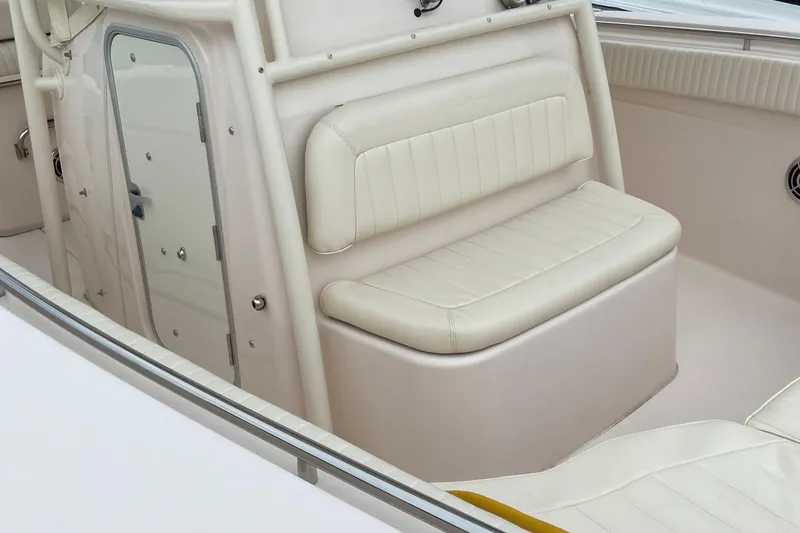 Slide: The Image of 2013 Grady-White Canyon 306 boat interior with cushioned seating and storage compartment. - 31
