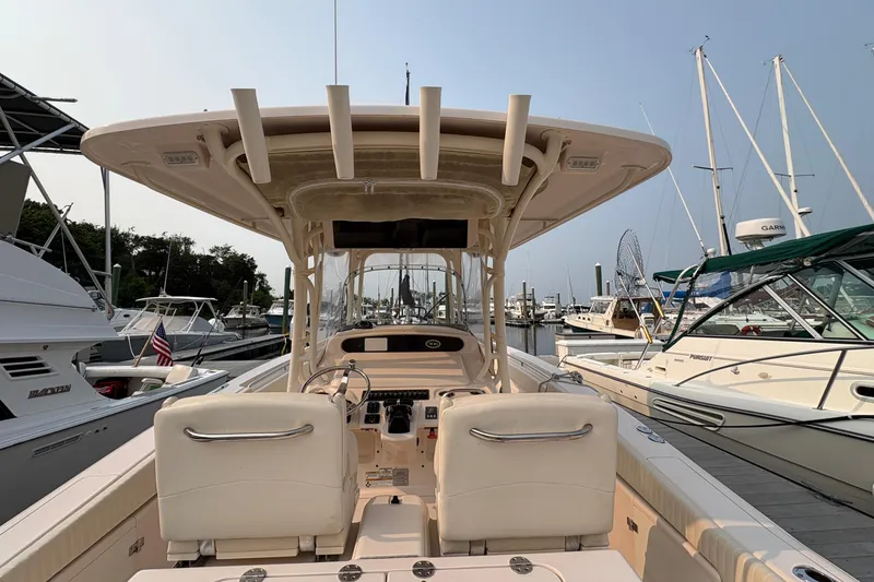 Slide: The Image of 2013 Grady-White Canyon 306 boat docked at marina, featuring helm and seating area. - 35