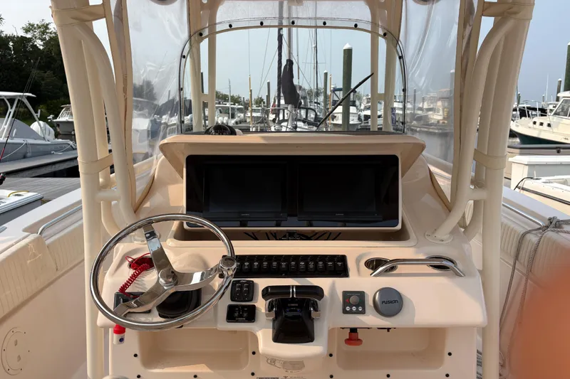 Slide: The Image of 2013 Grady-White Canyon 306 boat dashboard with steering wheel and navigation screens. - 38