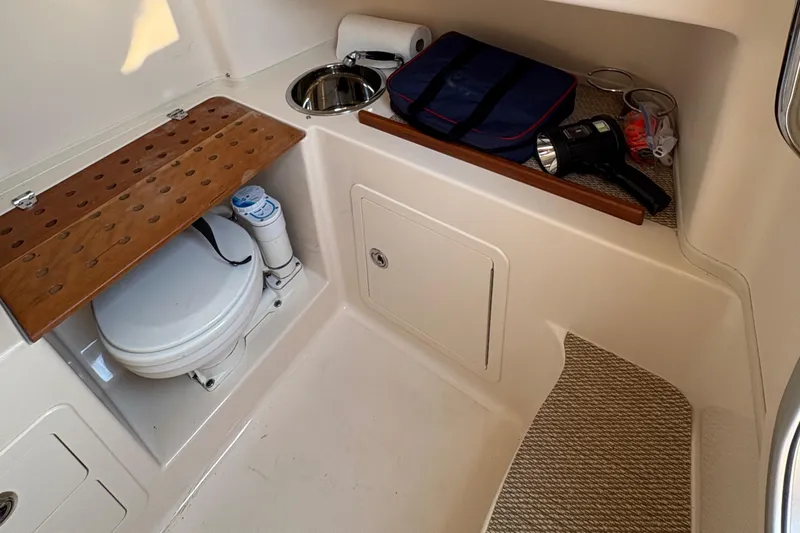 Slide: The Image of 2013 Grady-White Canyon 306 boat interior with toilet and storage area. - 47