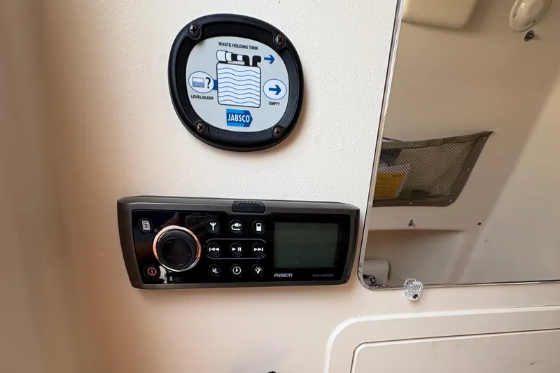 Slide: The Image of Control panel and waste tank gauge on 2013 Grady-White Canyon 306 boat. - 48