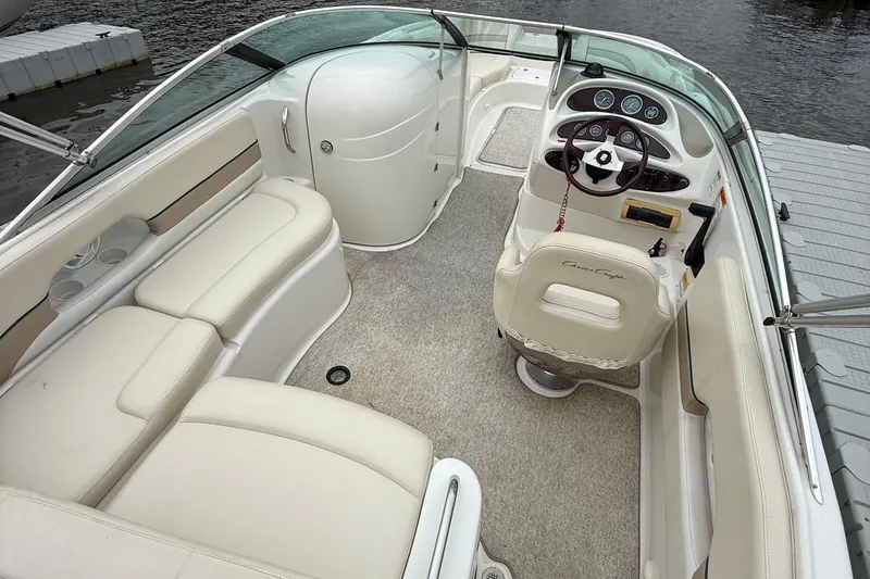 Slide: The Image of Interior of a 2000 Chris-Craft 230 Deck Boat with beige seating and steering console. - 4