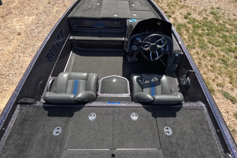 Slide: The Image of 2021 Bullet 21XRS boat interior with steering wheel and seating, on dry land. - 10