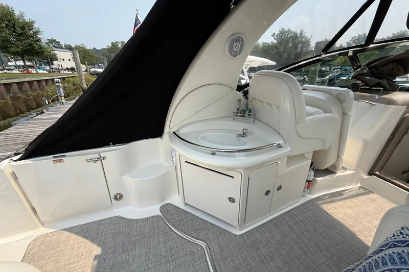 Slide: The Image of 2003 Sea Ray 340 Sundancer interior with sink and seating, docked at marina. - 12