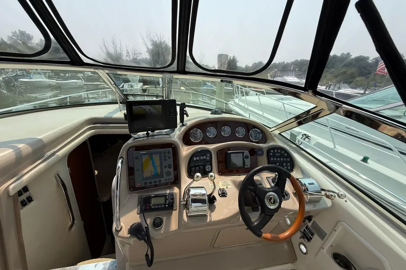 Slide: The Image of Cockpit of 2003 Sea Ray 340 Sundancer with navigation equipment and steering wheel. - 16