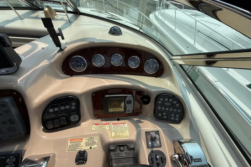Slide: The Image of 2003 Sea Ray 340 Sundancer helm with gauges and controls, featuring a sleek dashboard design. - 18