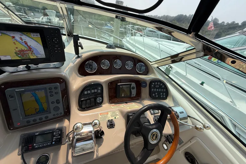 Slide: The Image of 2003 Sea Ray 340 Sundancer helm with navigation equipment and controls, docked at marina. - 21