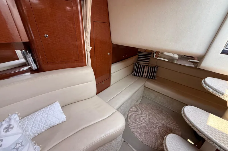 Slide: The Image of Interior of 2003 Sea Ray 340 Sundancer yacht with beige seating and wooden cabinetry. - 26