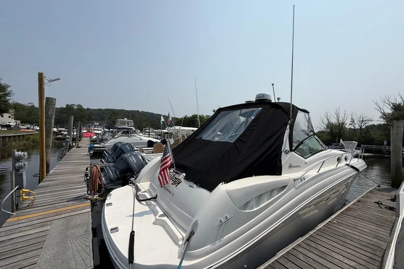 Slide: The Image of 2003 Sea Ray 340 Sundancer docked at a marina, featuring sleek design and American flag. - 3
