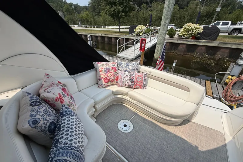 Slide: The Image of 2003 Sea Ray 340 Sundancer boat interior with floral cushions, docked by a canal. - 8