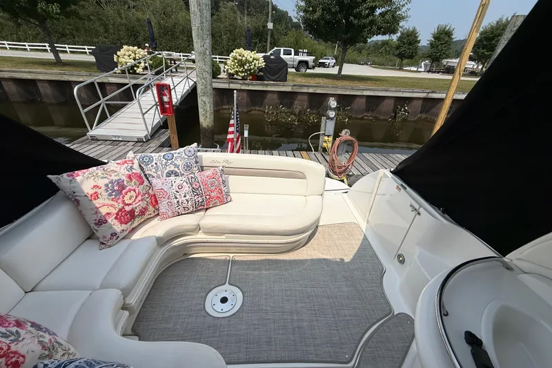 Slide: The Image of 2003 Sea Ray 340 Sundancer boat interior with floral cushions at a dock. - 9