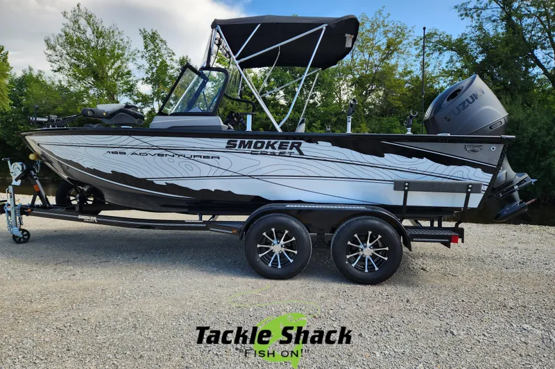 Slide: The Image of 2026 Smoker Craft Adventurer 188 DC PRO boat on trailer, outdoors with trees in background. - 2