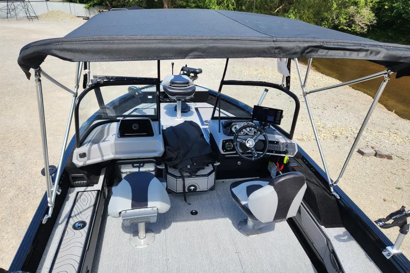 Slide: The Image of 2026 Smoker Craft Adventurer 188 DC PRO boat interior with canopy, steering console, and seating. - 25