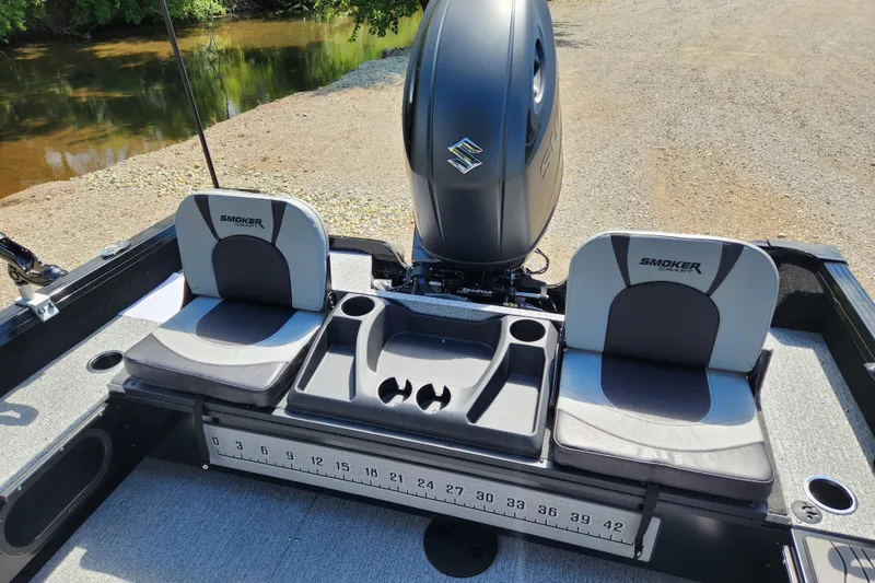 Slide: The Image of 2026 Smoker Craft Adventurer 188 DC PRO boat interior with seating and motor. - 6