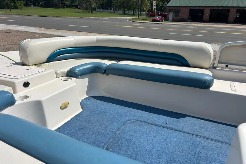 Slide: The Image of 2003 Hurricane FD228REF boat interior with blue and white seating, parked near a road. - 4