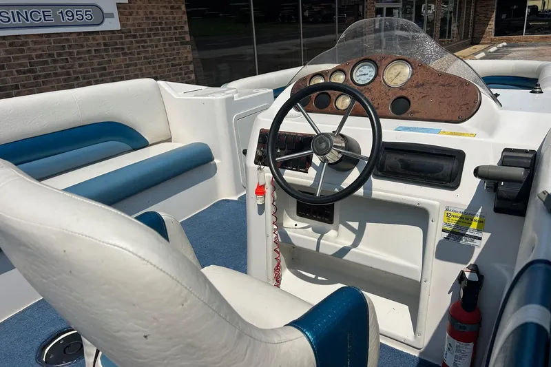 Slide: The Image of Interior of a 2003 Hurricane FD228REF boat with steering wheel and seating. - 9