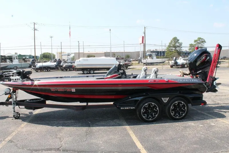 Slide: The Image of 2022 Skeeter FXR21 Apex bass boat with trailer, parked in a lot. - 5