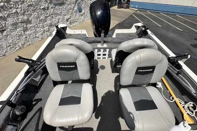 Slide: The Image of 2019 Tracker Pro Guide V-16 WT boat interior with two gray seats and fishing rod holders. - 12