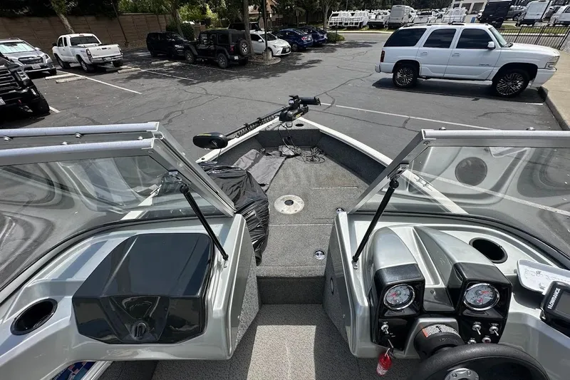 Slide: The Image of 2019 Tracker Pro Guide V-16 WT boat interior with dashboard and parking lot view. - 23