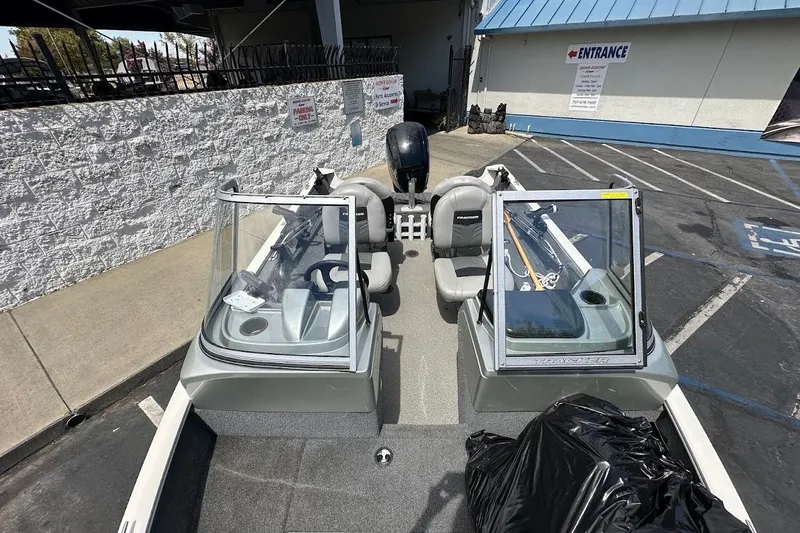 Slide: The Image of 2019 Tracker Pro Guide V-16 WT boat parked outdoors, featuring dual windshields and seating. - 26