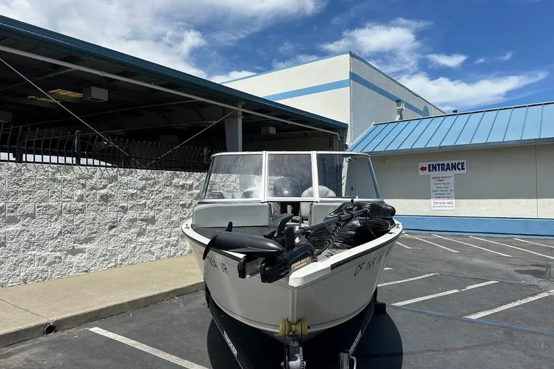 Slide: The Image of 2019 Tracker Pro Guide V-16 WT boat parked outside a building under a clear sky. - 3
