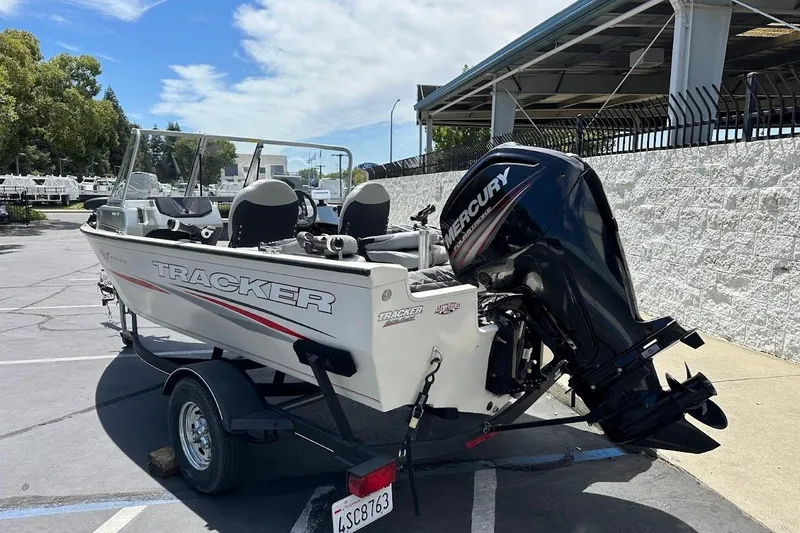 Slide: The Image of 2019 Tracker Pro Guide V-16 WT boat with Mercury outboard motor in a parking lot. - 8