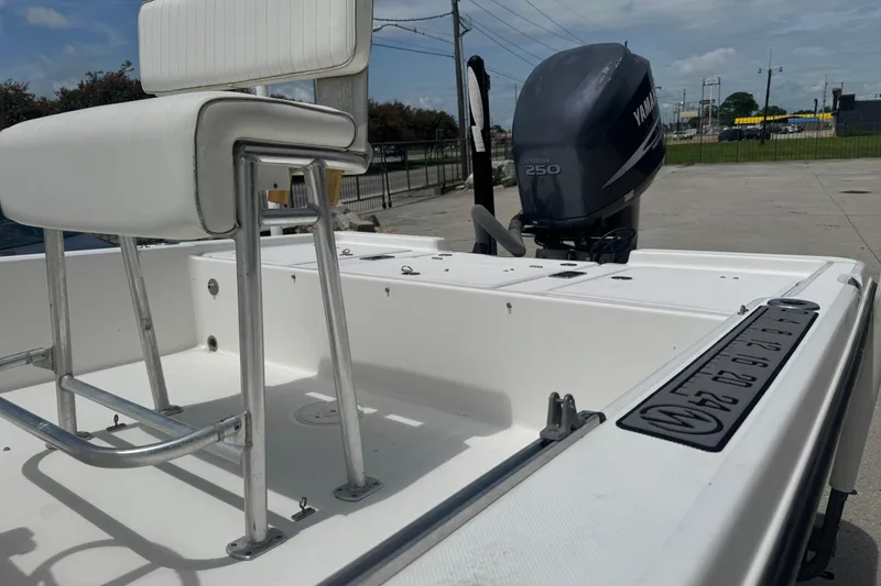 Slide: The Image of 2008 Century 2202 BAY boat with white deck, parked near a large garage. - 10