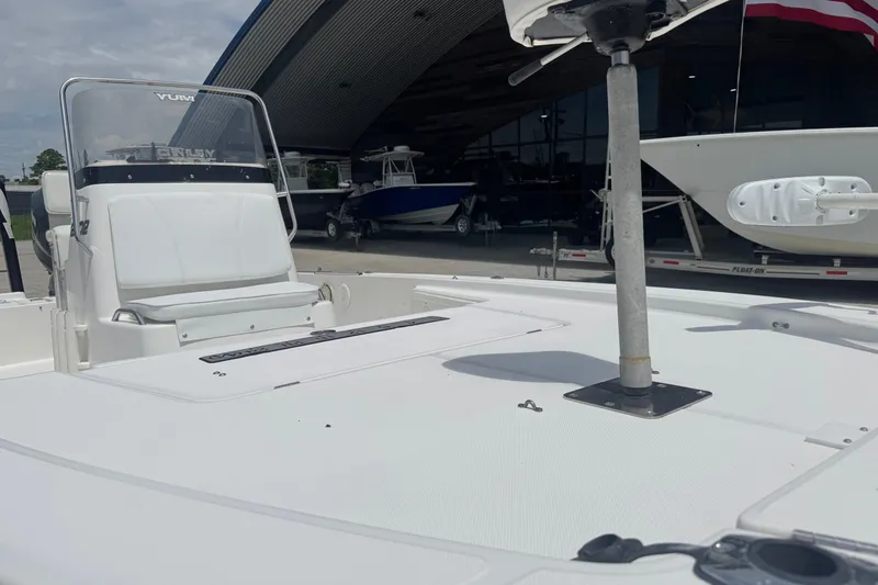 Slide: The Image of 2008 Century 2202 BAY boat, white deck, console view, outdoor setting, trees in background. - 12