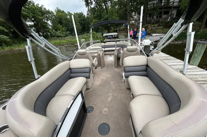 Slide: The Image of 2013 Premier 250 S-Series pontoon boat with spacious seating, docked by a lakeside. - 13
