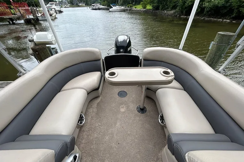 Slide: The Image of 2010 Premier 250 S-Series boat interior with cushioned seating and table on a calm river. - 21