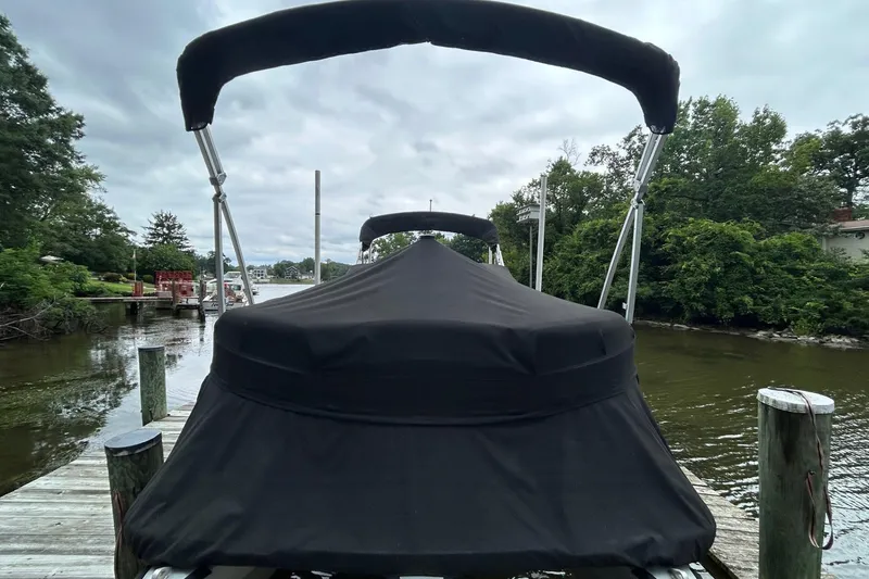 Slide: The Image of 2010 Premier 250 S-Series boat covered at dock, surrounded by lush greenery. - 27