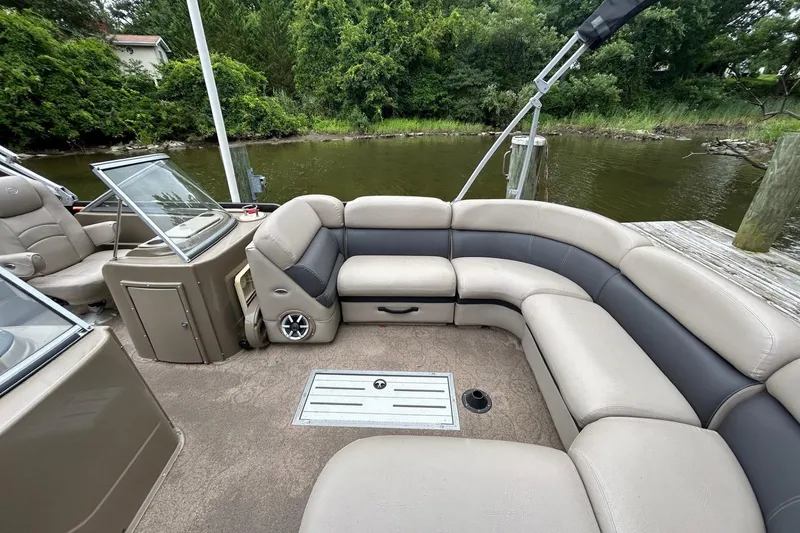 Slide: The Image of Premier 250 S-Series 2010 pontoon boat interior with plush seating by a serene lake. - 3