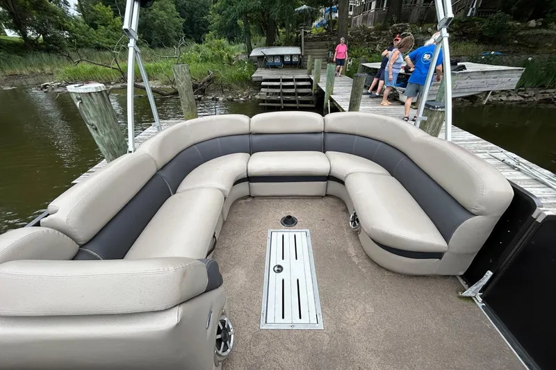 Slide: The Image of Pontoon boat interior with beige seating, Premier 250 S-Series, docked by a lake. - 4