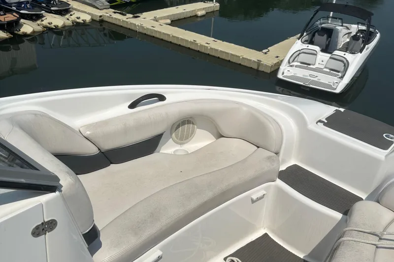 Slide: The Image of 2007 Yamaha Boats SX210 interior with cushioned seating at a marina. - 12