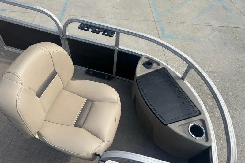 Slide: The Image of 2021 Sun Tracker Fishin' Barge 20 DLX boat interior with beige seating and storage area. - 10