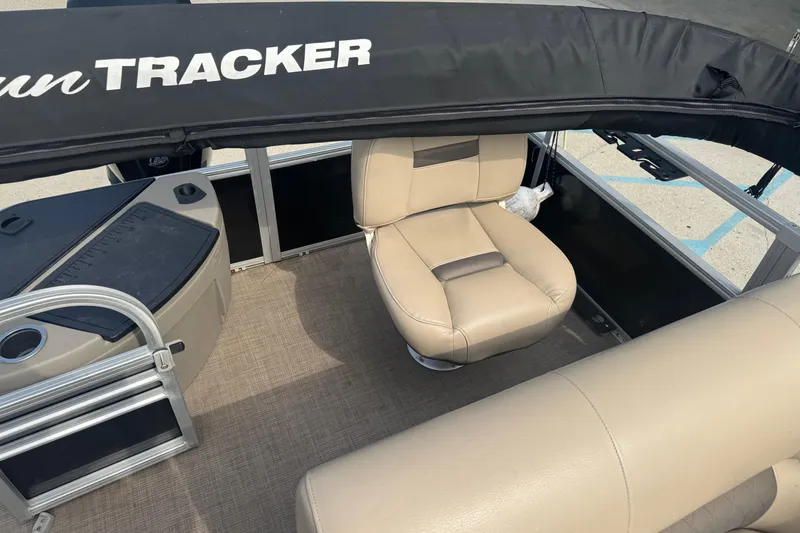Slide: The Image of 2021 Sun Tracker Fishin' Barge 20 DLX interior with beige seating and black canopy. - 12