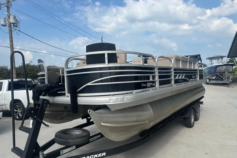 Slide: The Image of 2021 Sun Tracker Fishin' Barge 20 DLX pontoon boat on trailer, parked outdoors. - 4